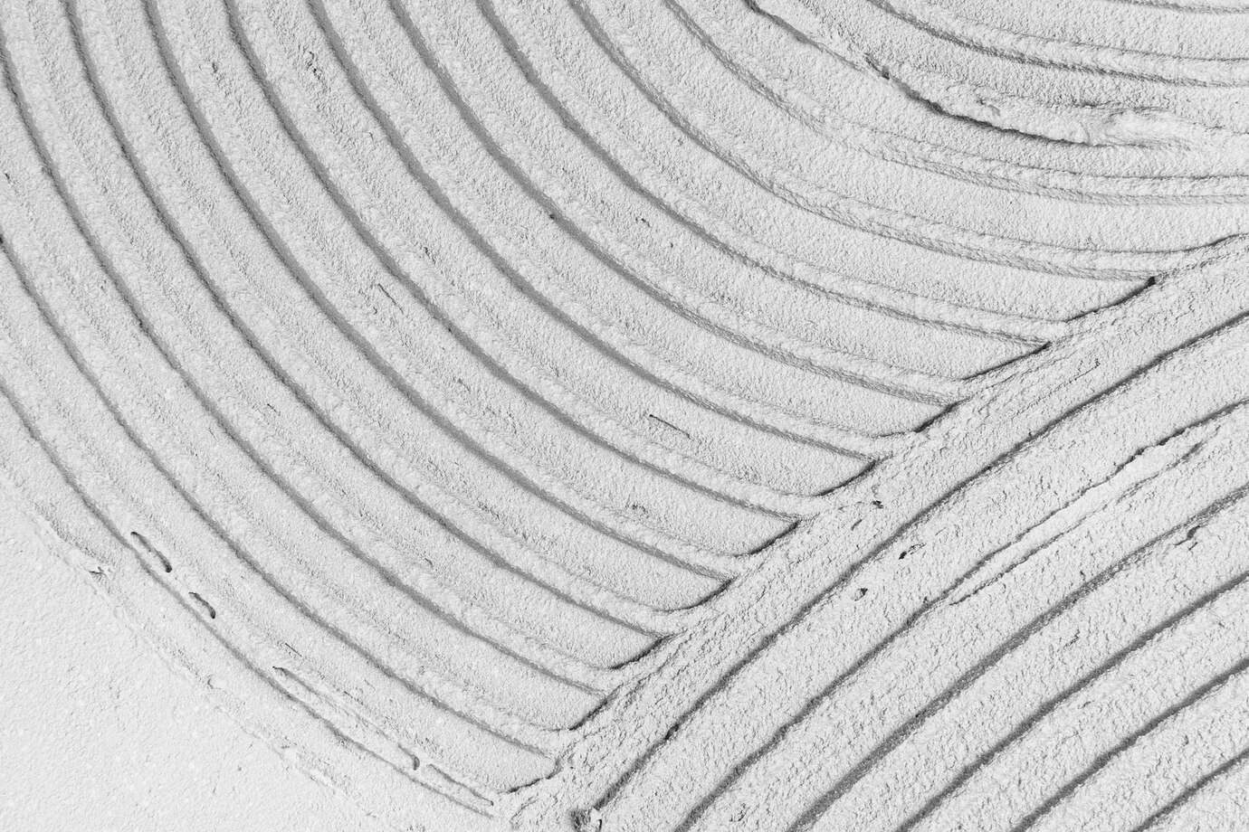 Поверхня стіни, покрита цементно-піщаним розчином із хвилястим візерунком.