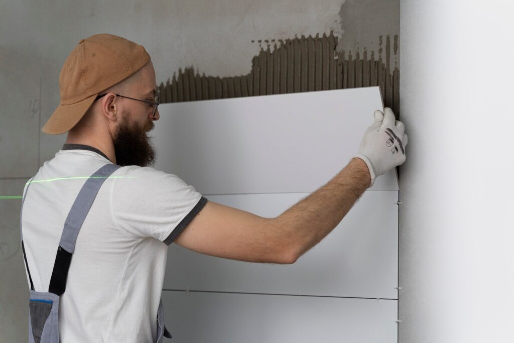 Майстер виконує утеплення стіни з газоблоків під час будівельних робіт.