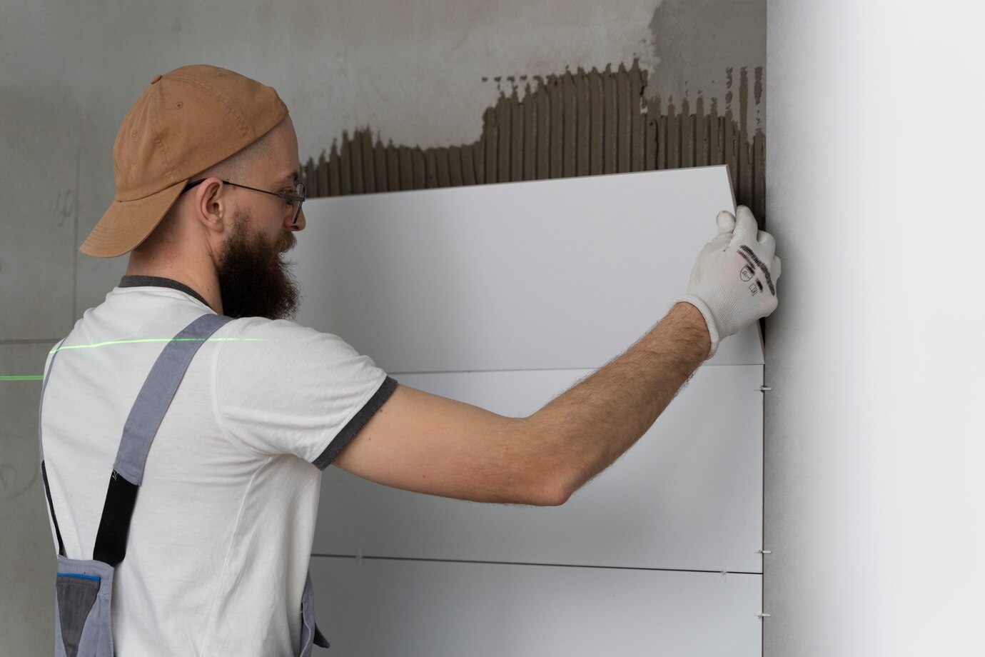 Майстер виконує утеплення стіни з газоблоків під час будівельних робіт.